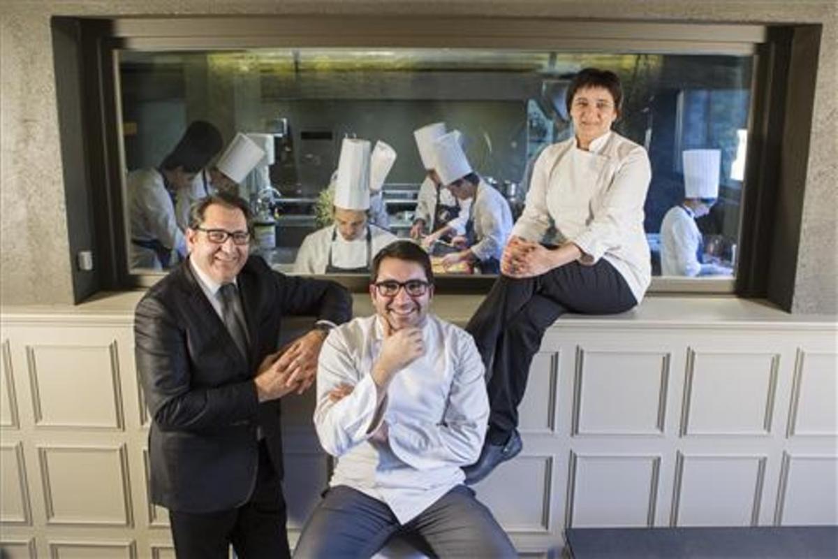 Joan, Jordi e Isabel Junca, ante la cocina de Ca l'Enric, en la Vall de Bianya.
