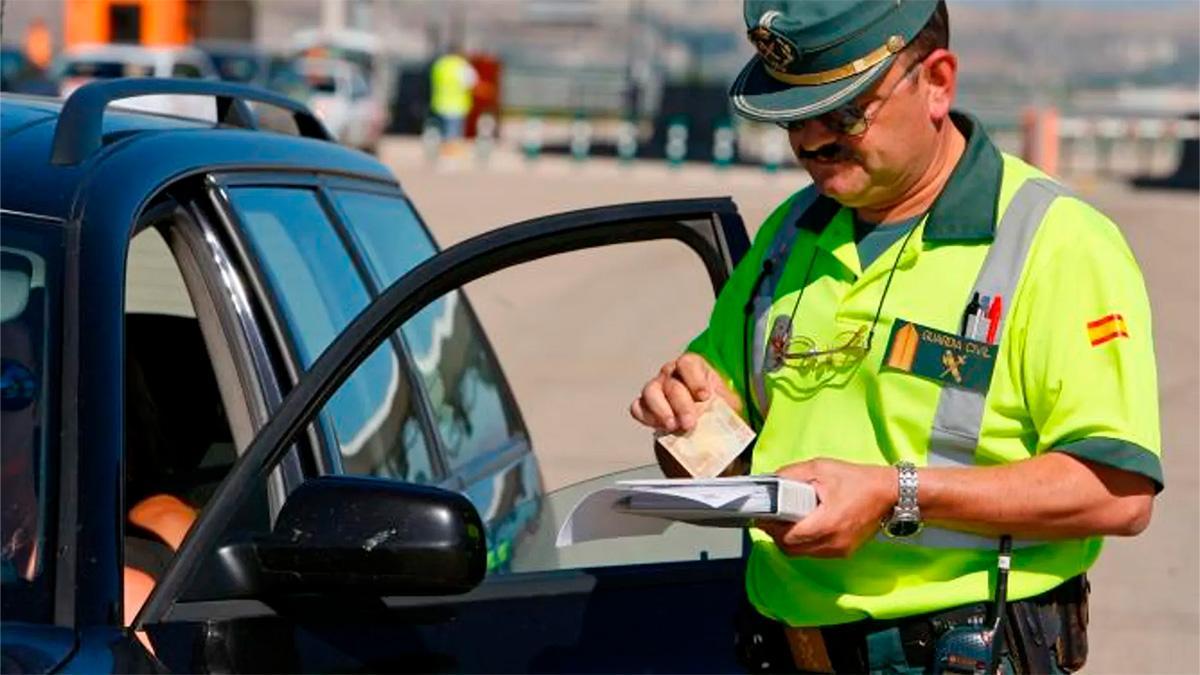 Un guardia civil multando a un conductor