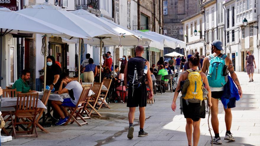 Turistas y peregrinos paseando el pasado agosto por una calle de la zona monumental de Santiago Foto: Fernando Blanco
