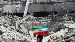 Un iraní coloca la bandera nacional de Irán entre las ruinas de una comisaría de policía dañada en el centro de Teherán, Irán, el pasado 4 de marzo de 2026