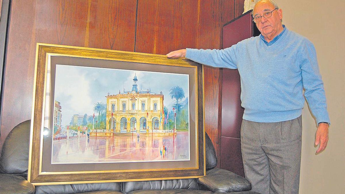 Manuel Busto, en su etapa de alcalde, con una acuarela que reproduce el Ayuntamiento de Villaviciosa. | LNEEL ALCALDE DE VILLAVICIOSA, MANUEL BUSTO, CON LA ACUARELA &quot;DESPUES DE LA LLUVIA&quot; DE HUMBERTO ALONSO, DONADA AL AYUNTAMIENTO POR EL AUTOR.