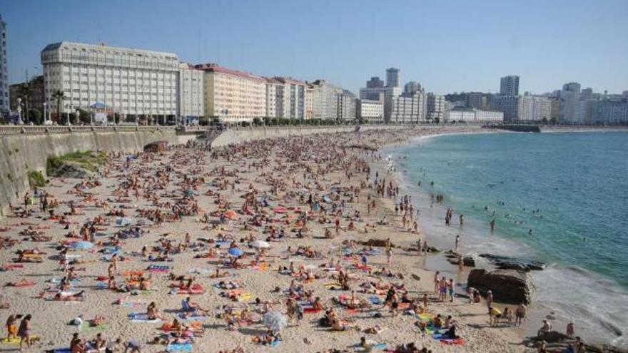 Numerosos bañistas abarrotan la playa del Orzán en un día despejado. / loc