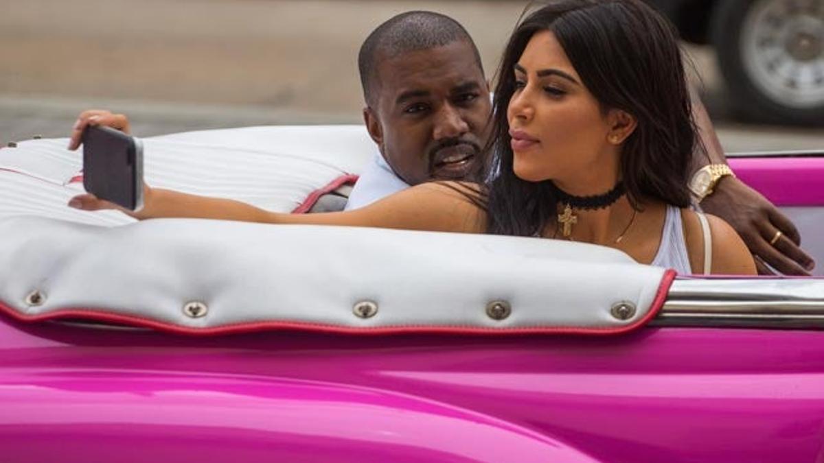 Kim Kardashian se hace un selfie en el descapotable fucsia ante la atenta mirada de Kanye West