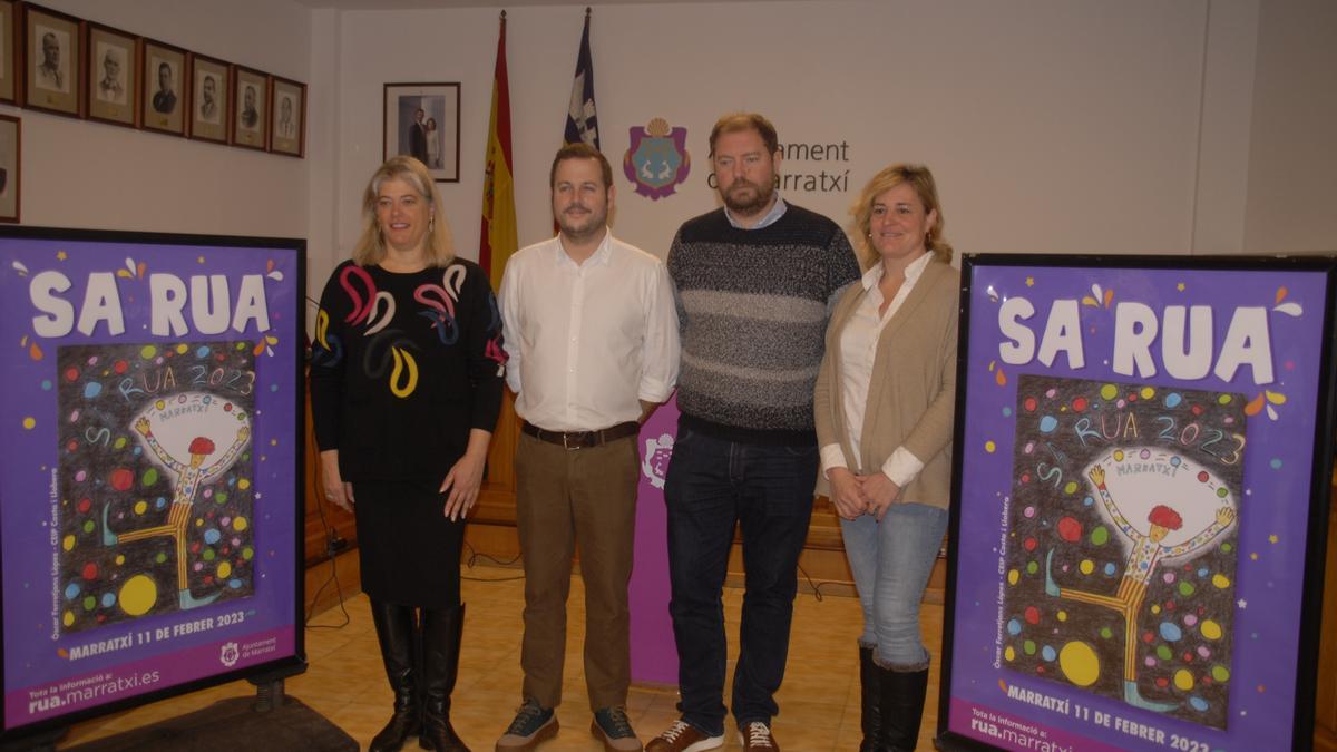 Las autoridades municipales posan junto al cartel ganador del concurso de este año.