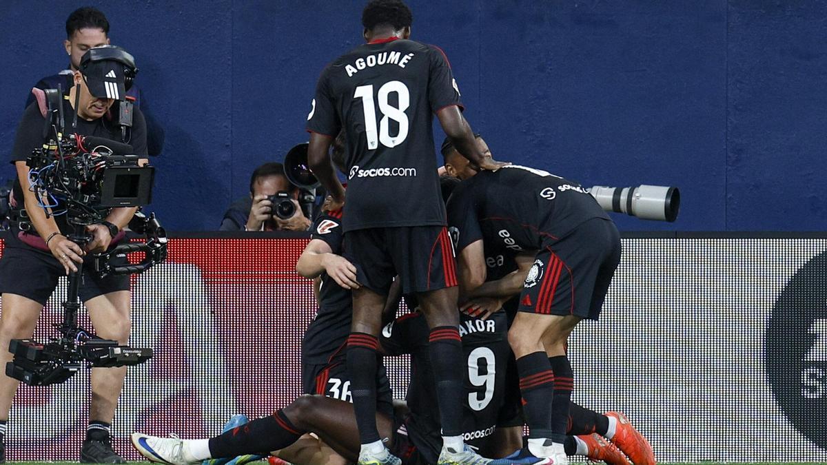 El delantero nigeriano del Sevilla FC Akor Adams (en el suelo) celebra junto a sus compañeros.