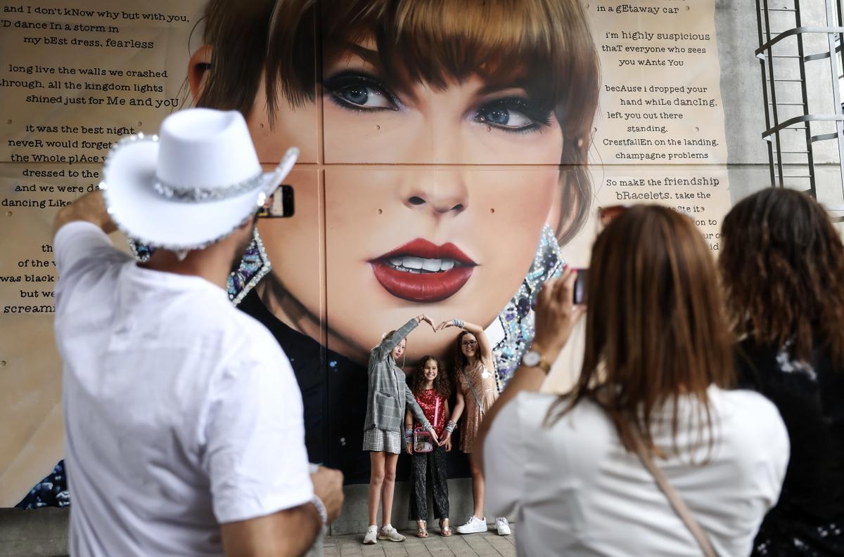 Fans de Taylor Swift junto a un mural de la cantante a las afueras del estadio de Wembley este jueves