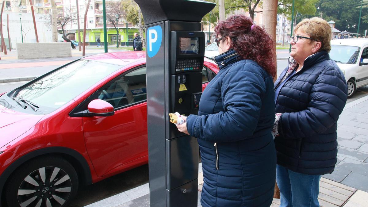Dos mujeres, ante una máquina para pagar en la Zona Azul de Gandia.
