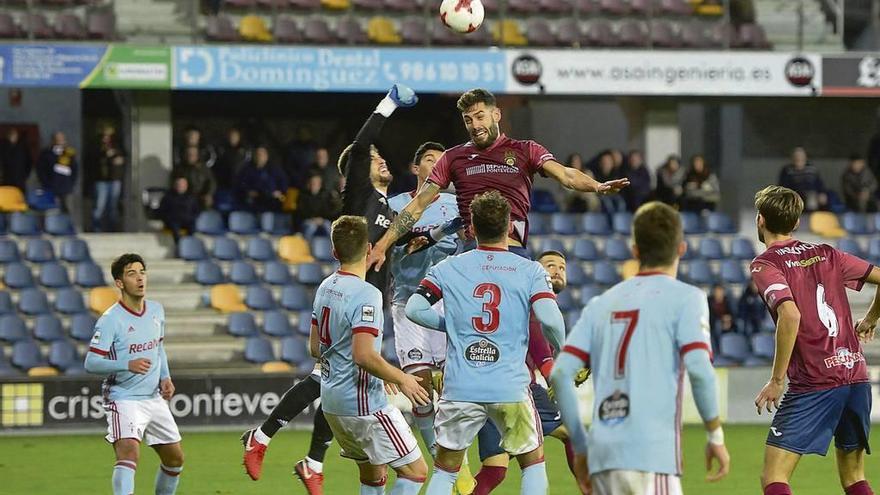 Jero, portero del Celta B, sale de puños a disputar un balón aéreo con el granate Adrián León tras un saque de esquina. // G. Santos