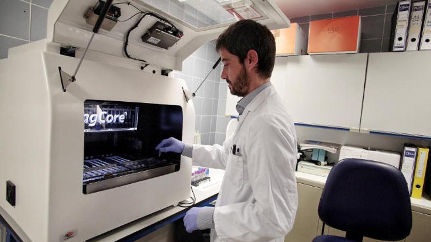 Técnicos de labotario proceden a la agitación de una muestra durante el proceso de purificación del ADN.