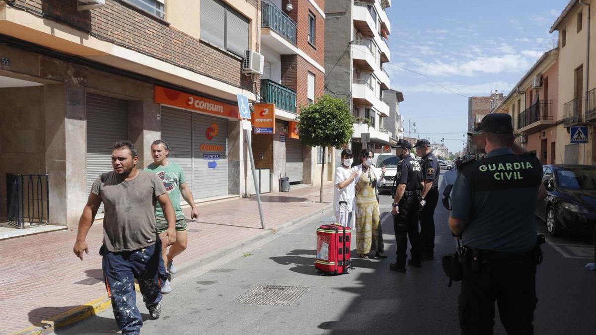 El marido de la víctima, a la izquierda, al regresar ayer a la vivienda. | JM LÓPEZ