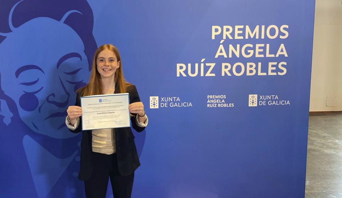 Carla Piñeiro muestra el reconocimiento.