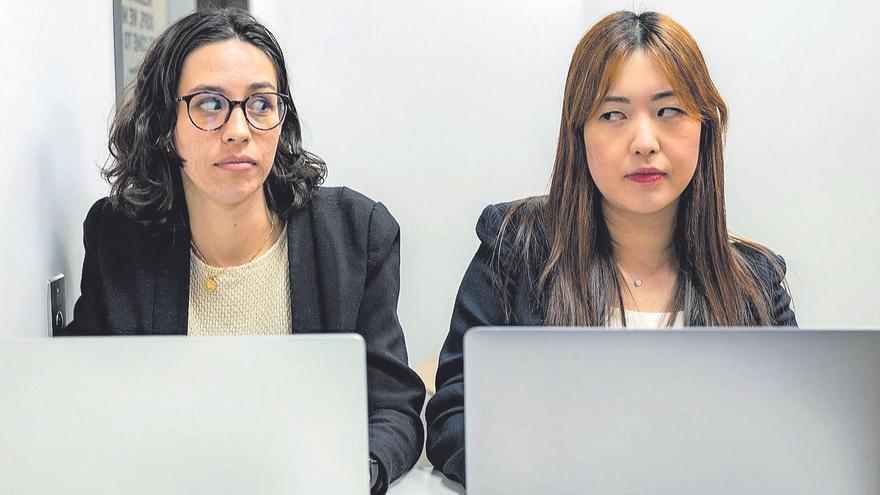 Dos personas mirándose mientras trabajan en su ordenador