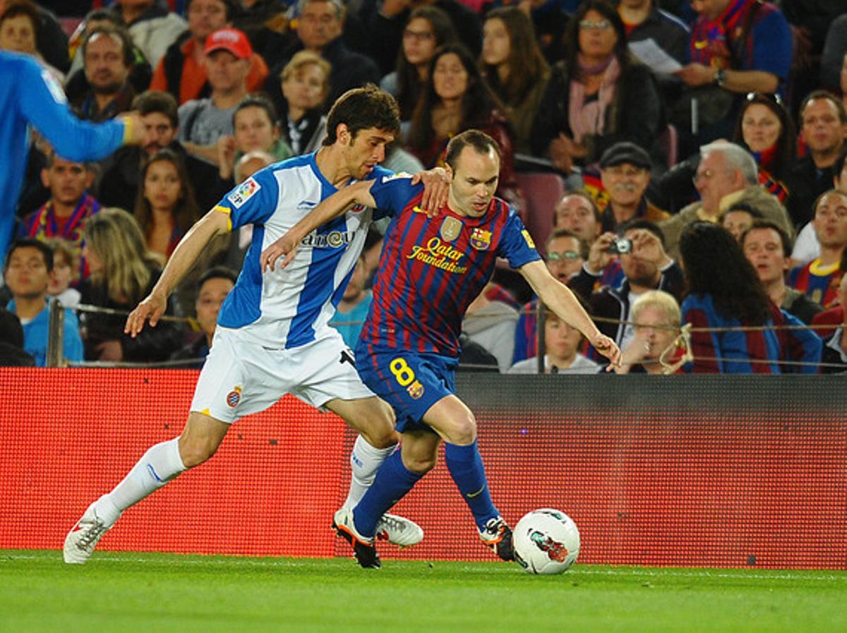 Iniesta supera a Forlín en la banda en partido entre el Barça y el Espanyol con el Camp Nou de gala.