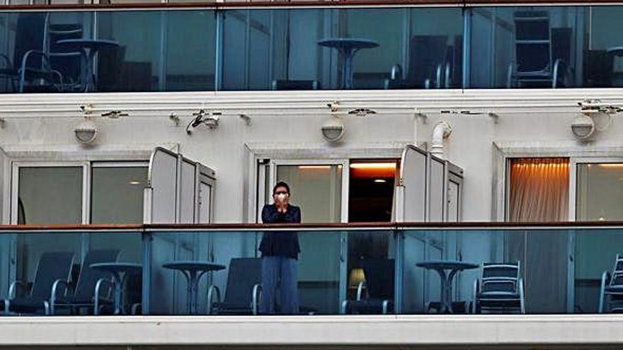 Un hombre con mascarilla en el crucero en cuarentena en el puerto de Yokohama.