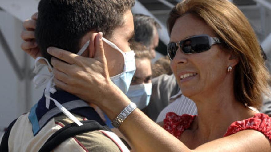 Arriba, una madre recibe a su hijo ayer en el muelle de Cambulloneros de la capital grancanaria. Debajo, dos escenas de intensa emoción de varios padres al reencontrarse con sus hijos tras la expedición a Madeira.