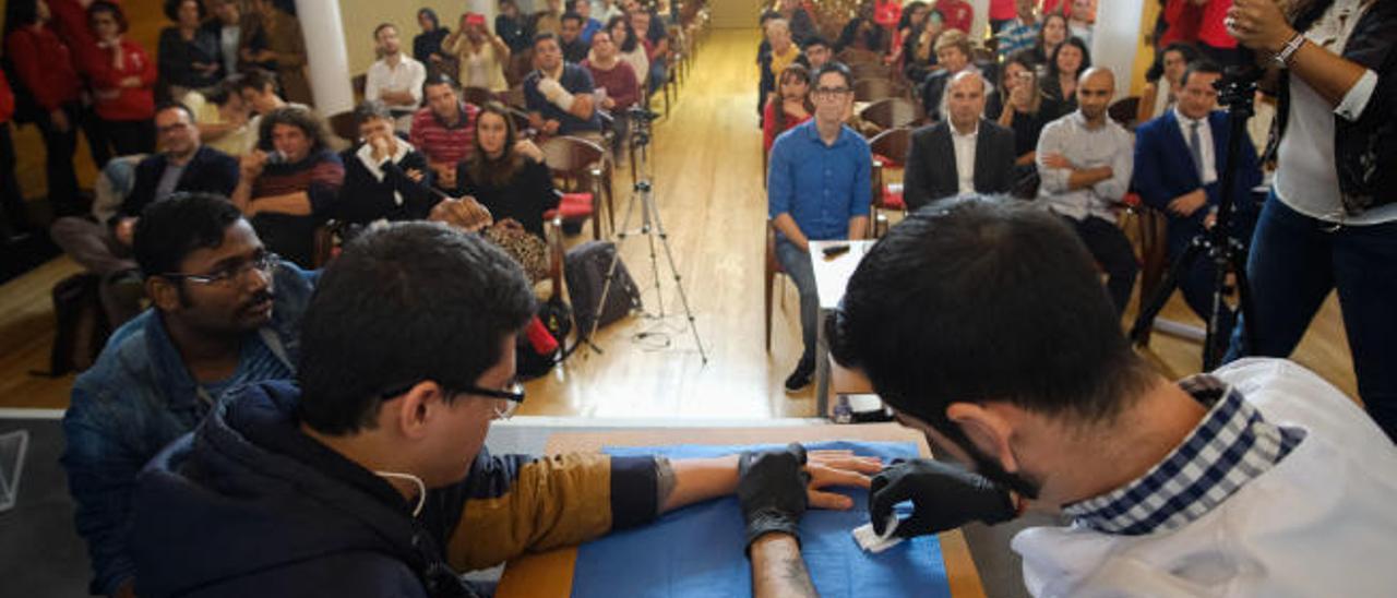 Implante de un microchip en la mano de un joven, en la clausura del proyecto InsertaTIC de la Fundación Universitaria.