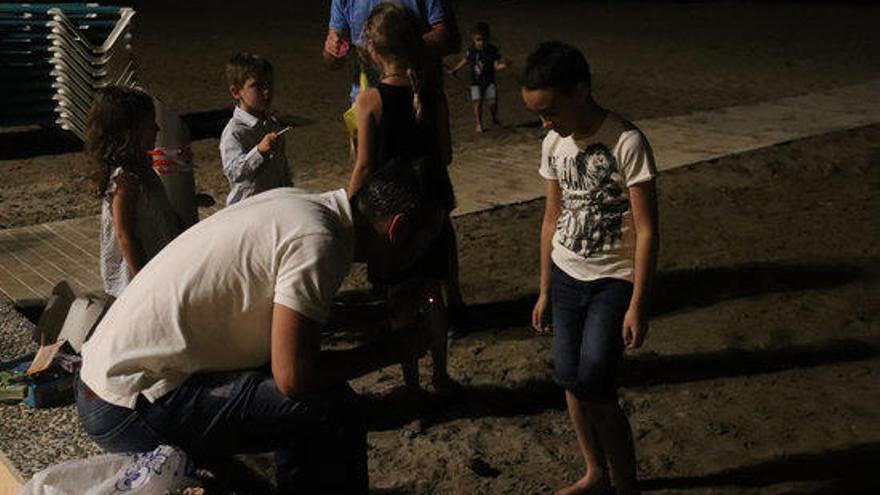 Famíles amb nens celebrant la revetlla a la platja.