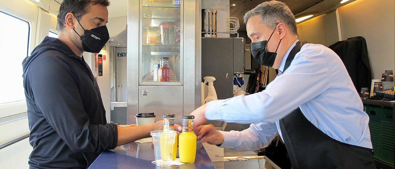 Jordi de Miguel sirve un zumo de naranja a un viajero extranjero, este miércoles, en el Euromed Figueres-Alicante.