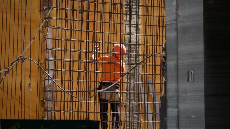 Un operario extranjero trabaja en la obra de un edificio.