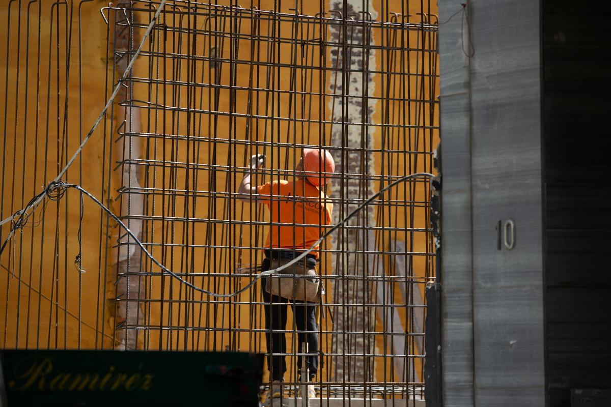 Un operario extranjero trabaja en la obra de un edificio.