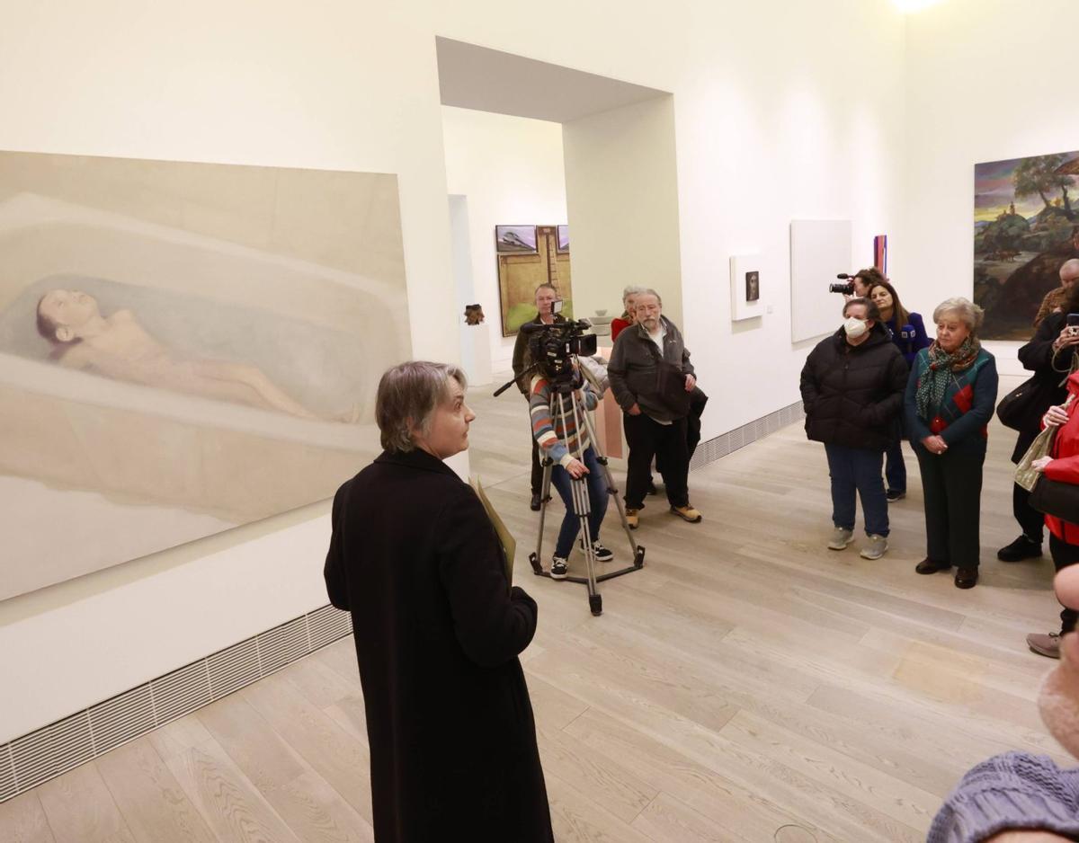 Cristina Rodríguez Paz, en el centro, ante el cuadro «Le petit hotel», de Juan Fernández Álava, durante la visita guiada al Museo de Bellas Artes.  | MIKI LÓPEZ