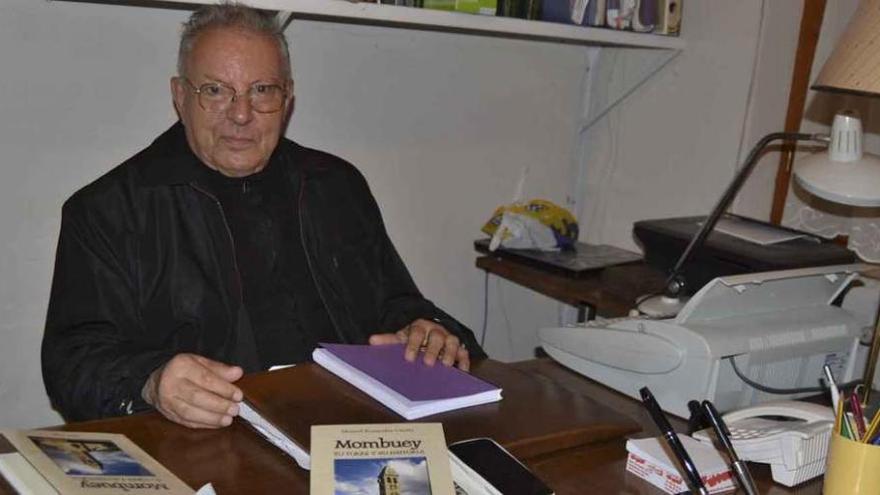 El párroco Manuel Benavides con el nuevo libro sobre la mesa de su despacho.