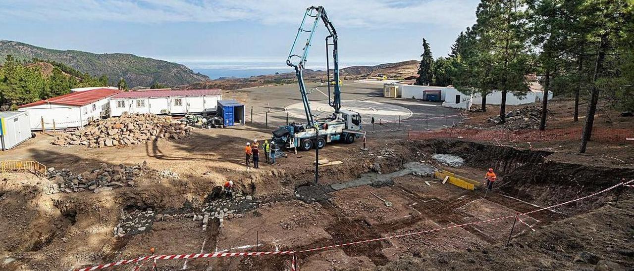 Varios trabajadores en una obra de urbanización de un solar.