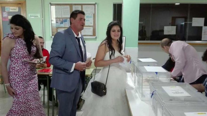 Pilar Otero Romero (derecha) acudió a votar vestida de novia en compañía de su padre (centro). // N. P.