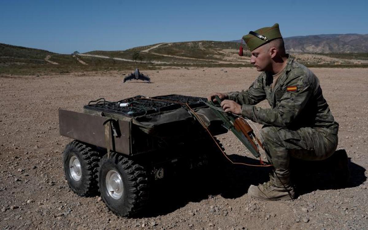 El legionario Francisco Navarro observa el UGV Adriano que llevará cordón explosivo a una barrera de minas.