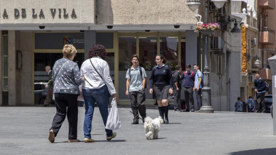 Vecinos con sus perros junto al ayuntamiento.