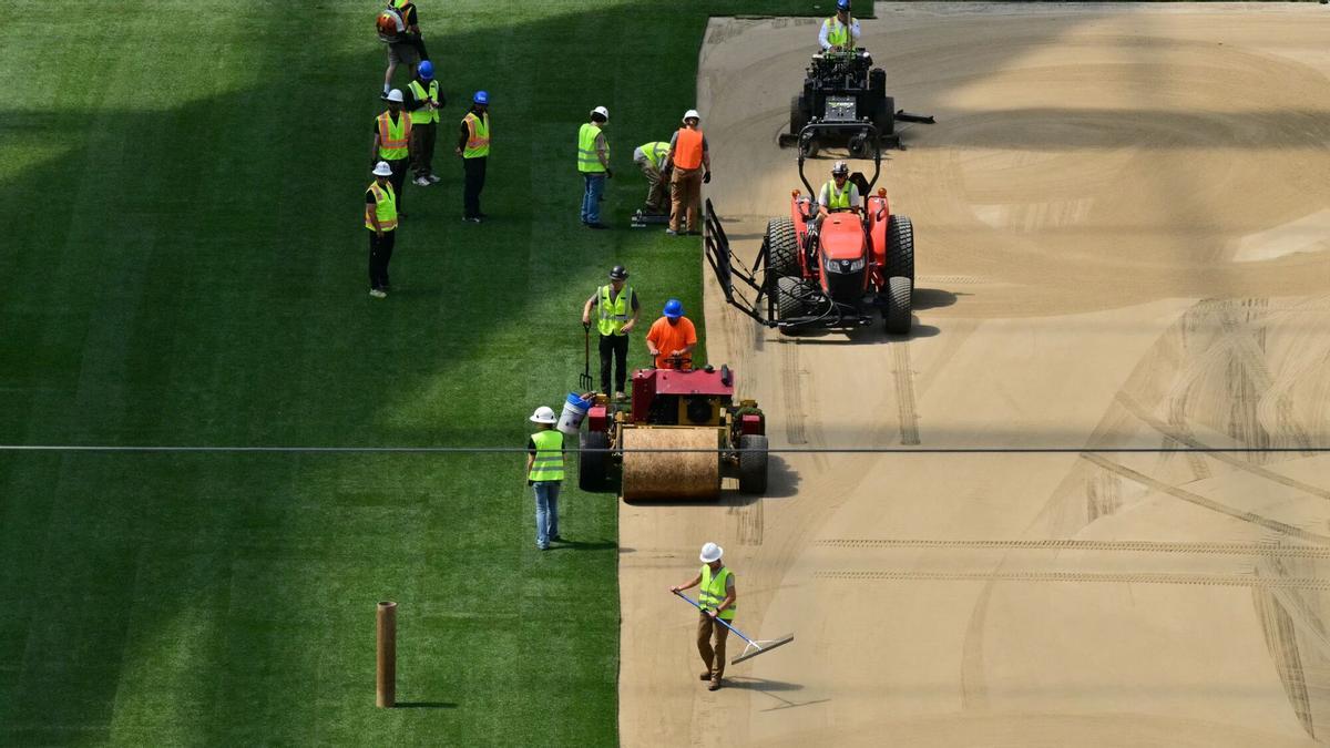 Los trabajadores instalan césped en el campo en el SoFi Stadium en Inglewood, California, antes de su cambio de nombre temporal al Estadio de Los Ángeles para la Copa del Mundo el 13 de mayo de 2026.