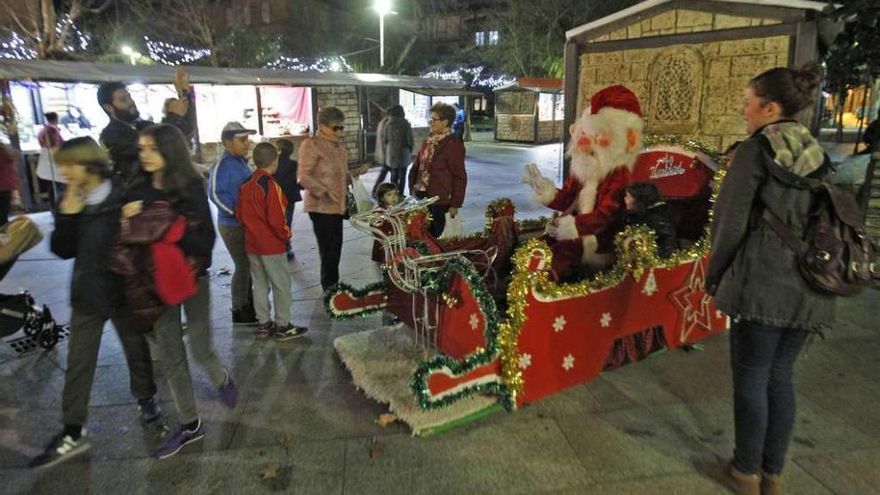 Papá Noel ayer en la entrada del primer mercadillo navideño de Ourense ubicado en la Plaza Bispo Cesáreo. // Jesús Regal