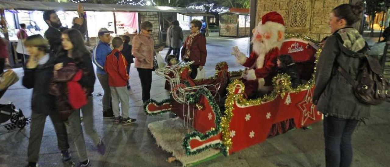 Papá Noel ayer en la entrada del primer mercadillo navideño de Ourense ubicado en la Plaza Bispo Cesáreo. // Jesús Regal