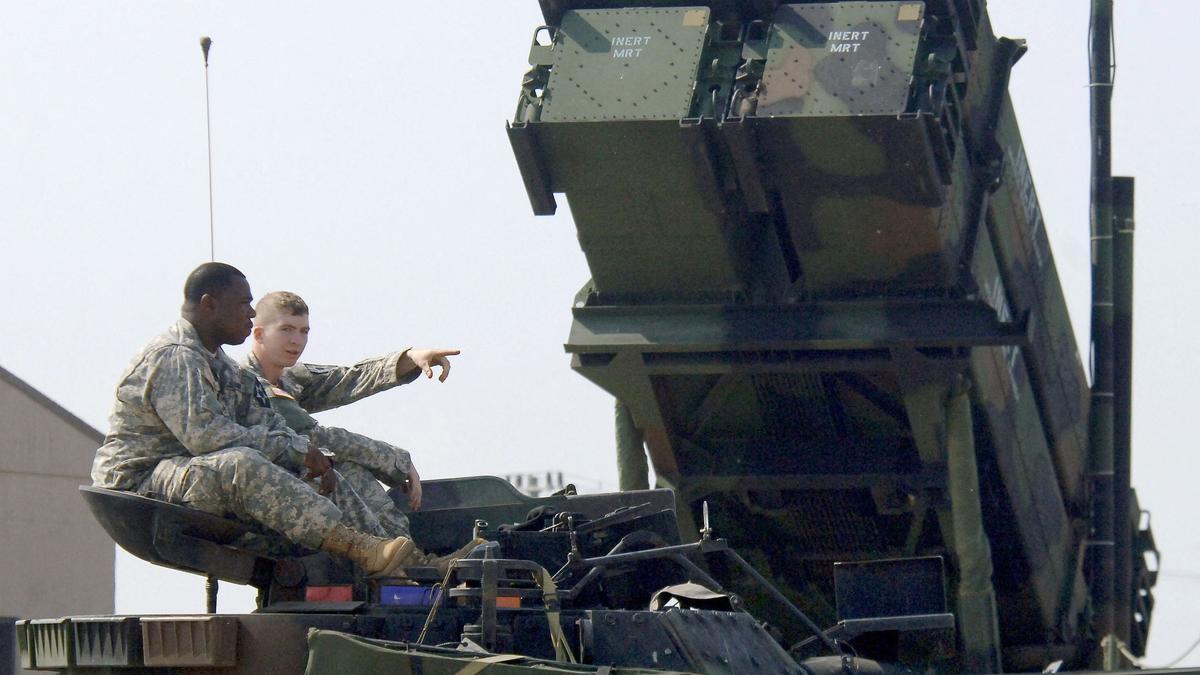 Un carro de combate Bradley pasa frente a un sistema de defensa antiaéreo Patriot en la base de EEUU en Corea del Sur.