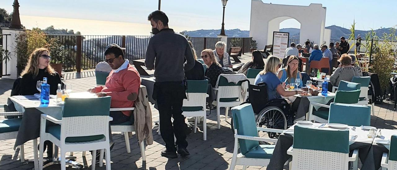 Un grupo de turistas almuerzan en el exterior de una terraza