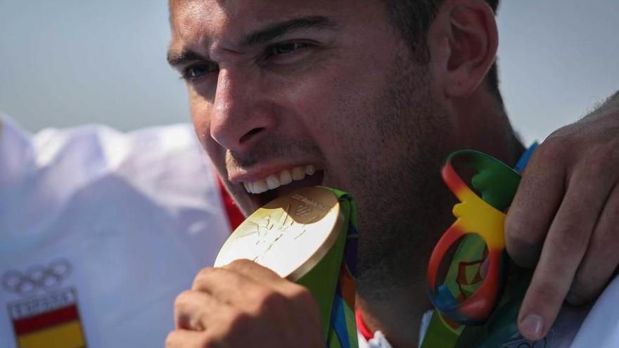 Cristian Toro muerde la medalla de oro en el podio.