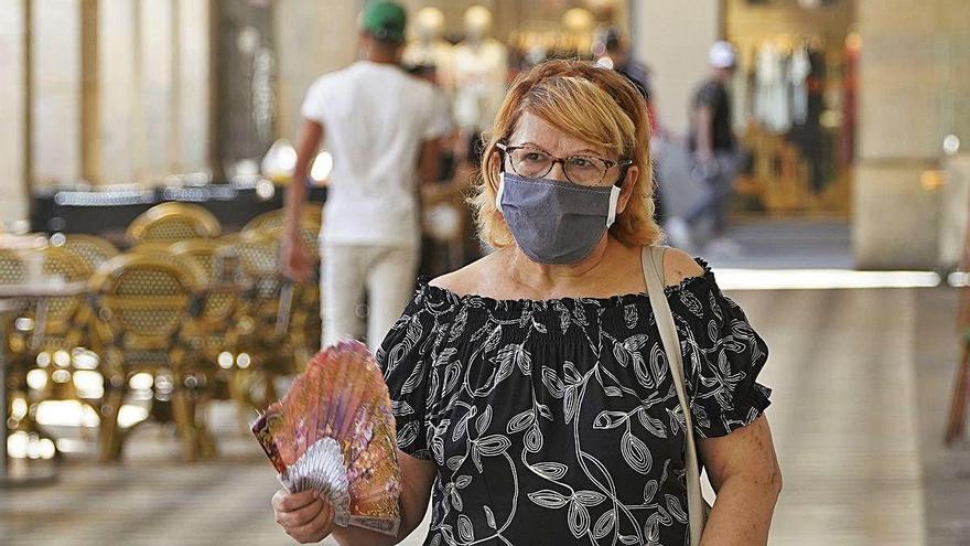 Una dona es venta mentre passeja pel centre de Girona.