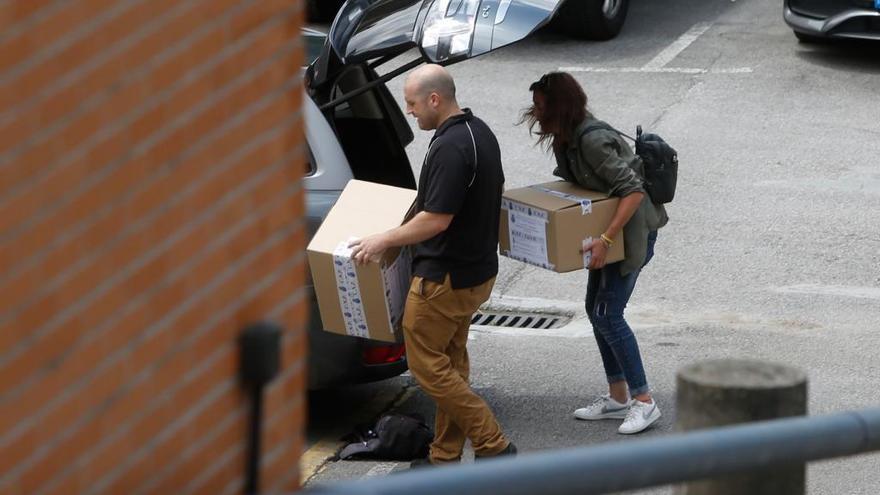 Dos investigadores cargan cajas de documentos después de registrar el cuartel del Rubín