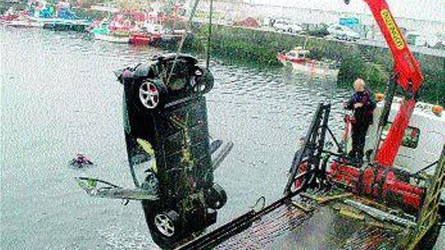 Una grúa retira el vehículo accidentado, con ayuda de dos submarinistas. / rep. gustavo santos