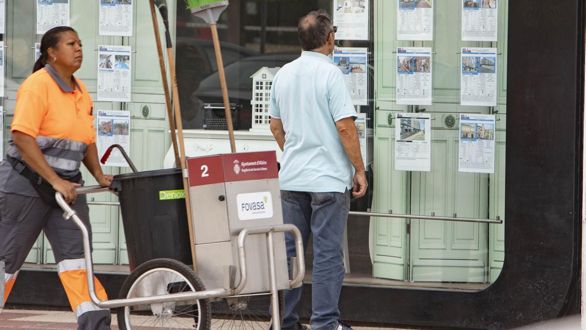 Un hombre revisa los anuncios de una inmobiliaria en Alzira, en una imagen de archivo.