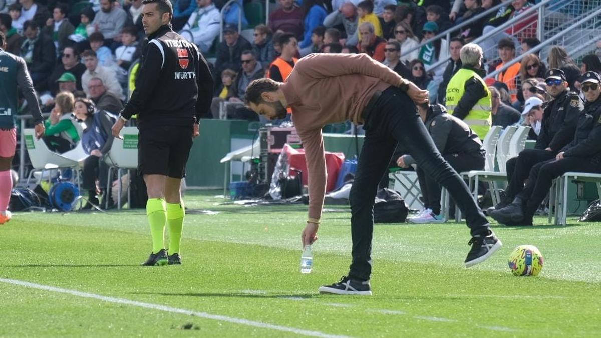 Machín coloca una botella durante el partido contra el Espanyol