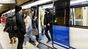 Varias personas suben y bajan de un metro en el andén de la estación de Metro de Callao, a 26 de enero de 2023, en Madrid (España).