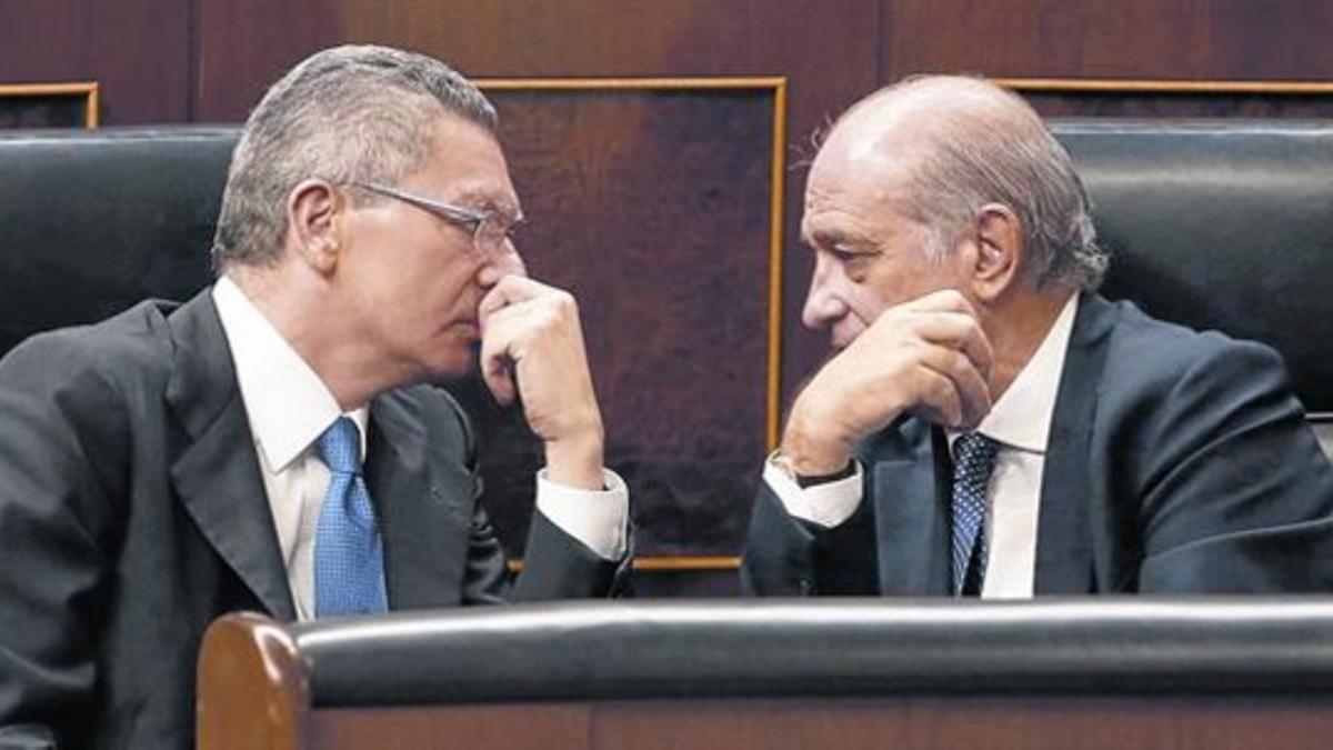 Los ministros Alberto Ruiz-Gallardón y Jorge Fernández Díaz conversan, el pasado 19 de septiembre, en el Congreso de los Diputados.