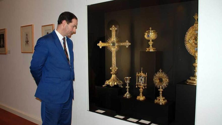 El encargado del Museo de Covadonga, Javier Remis, observa varias piezas, entre ellas un ostentorio en forma de cruz, de plata sobredorada con diamantes y perlas, donado en 1902 por Paz Blanco, viuda de Trelles.