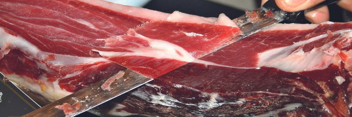 Cortando jamón, un manjar creado tras siglos de selección ganadera y artesanía en su curado.