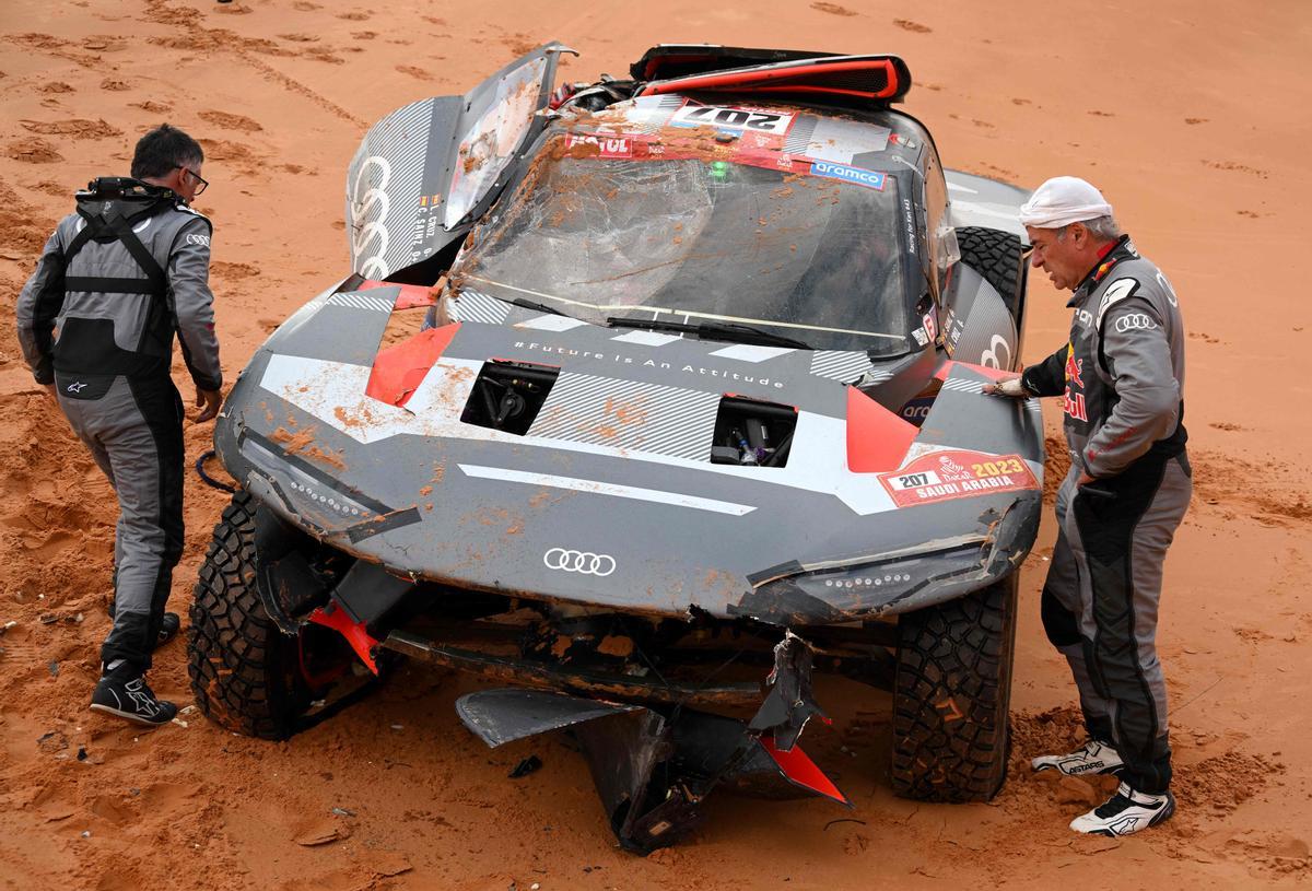 Carlos Sainz y su copiloto Luca Cruz, inspeccionan su automóvil después de un accidente durante la Etapa 9 del rally Dakar.