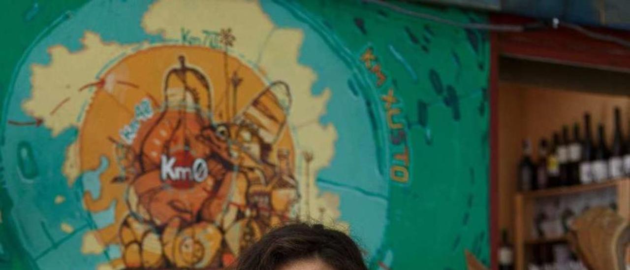 Raquel Doallo posa delante del mural que la cooperativa realizó en la Praza de Abastos. // Bernabé