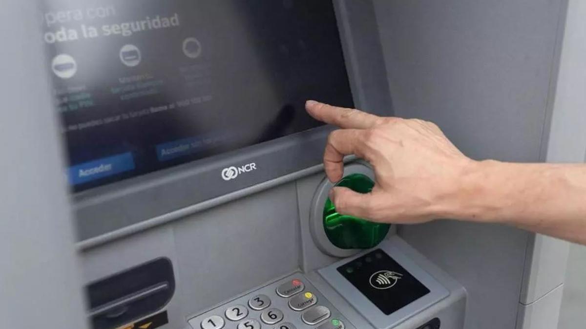 Un hombre extrae dinero de un cajero