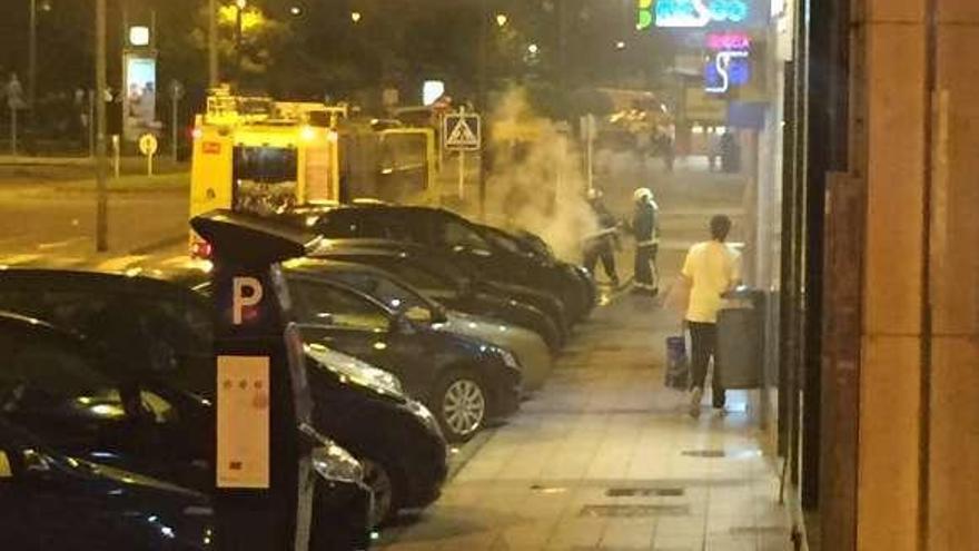 Los bomberos, apagando las llamas de un contenedor en la avenida de San Agustín en la madrugada del sábado.