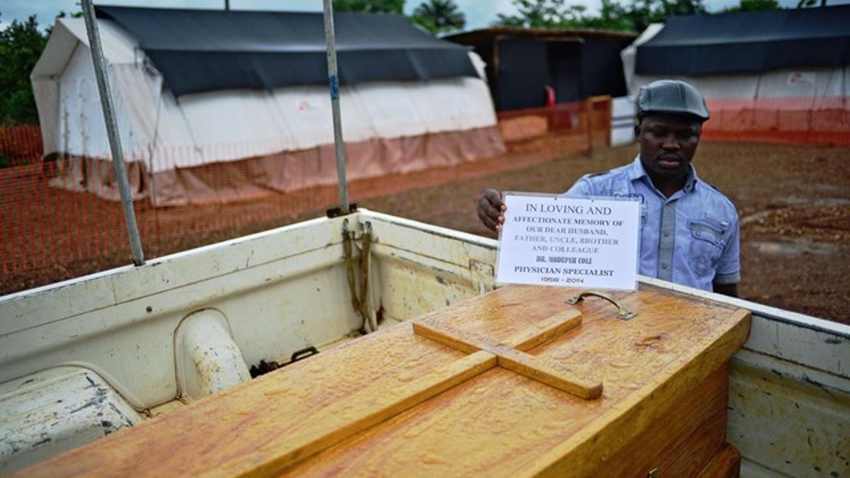 Un hombre en las instalaciones de Médicos sin Fronteras acompaña el ataúd del doctor Modupeh Cole, el segundo médico senior de Sierra Leona, que murió este jueves a causa del ébola.